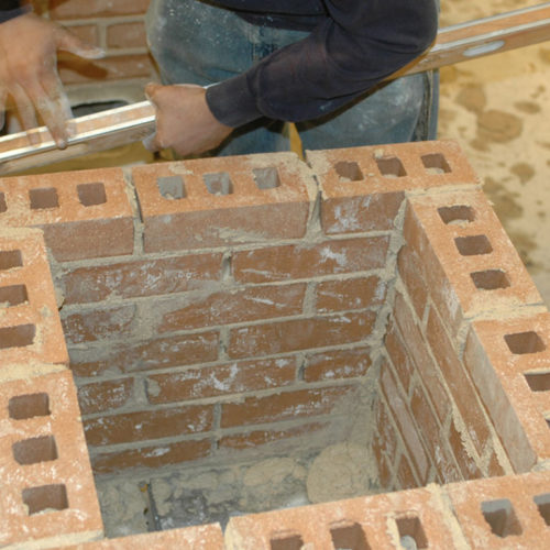 masonry student creates a brick tower