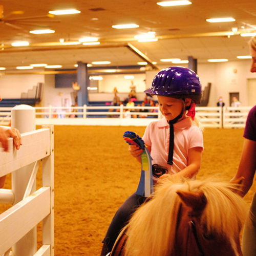 A participant looks proudly at her ribbon