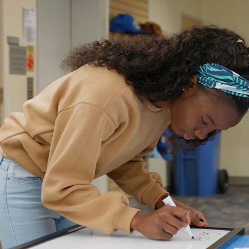 Student-Writing-Message-on-White-Board