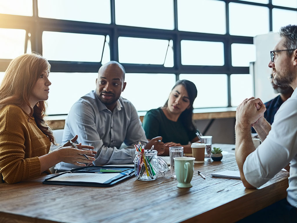 Workers-Sitting-at-a-Table-Featured