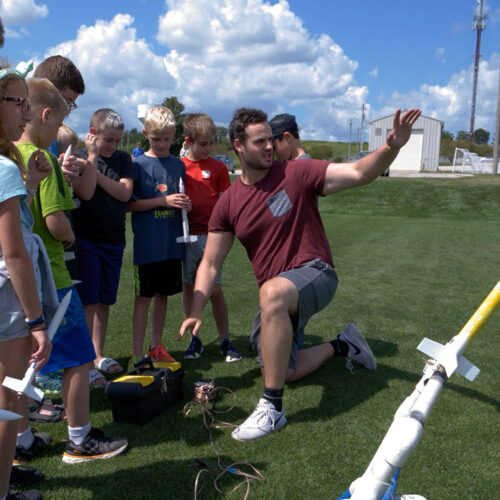 Kick-Camp-Instructor-with-Kids-and-Model-Rockets