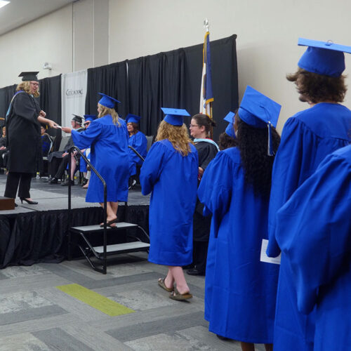 Graduates-line-up-to-walk-across-stage-featured