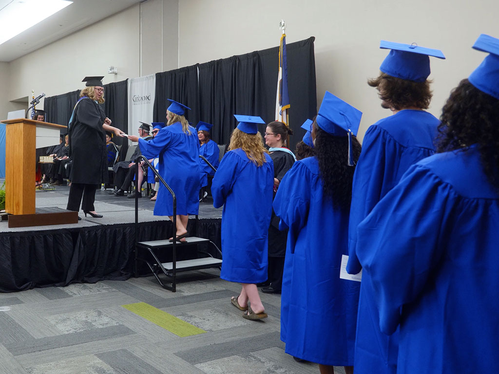 Graduates-line-up-to-walk-across-stage-featured