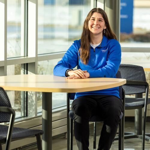 Megan-Stadtmueller-Sitting-at-a-Table-Featured